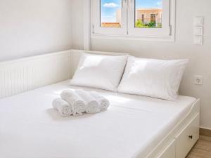 a white bed with three rolled towels on it at Ionian Studio in Lixouri