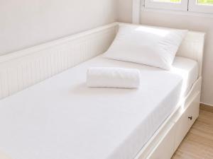 a white bed with a white pillow on it at Ionian Studio in Lixouri
