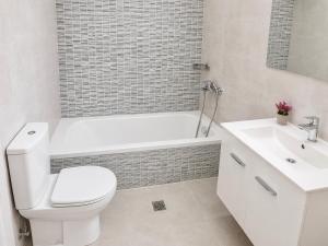 a white bathroom with a toilet and a sink at Ionian Studio in Lixouri