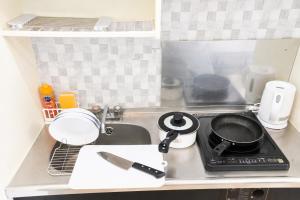 a kitchen with a sink and a stove with a pan on it at 宇都宮ハウスリリー in Utsunomiya
