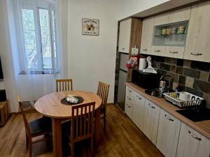 a kitchen with a wooden table and a table and chairs at Vila Dara 1924 in Tivat