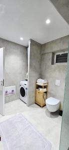 a bathroom with a washing machine and a washer at Promenade Apartment ,Sea view in Durrës +7 photos