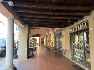a building with tables and chairs on a street at I Liutai 2P in Cremona +10 photos