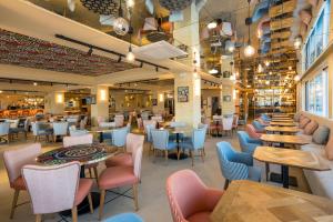 a restaurant with many tables and chairs and tablesktop at Hotel Kalura in Cefalù