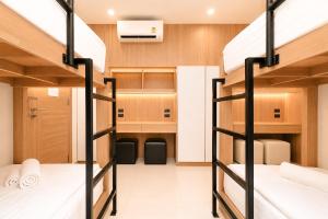 a bedroom with two bunk beds in a room at Love Rawai Hotel in Rawai Beach