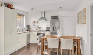 a kitchen with a wooden table and white cabinets at Welcome to Wigan in Gore
