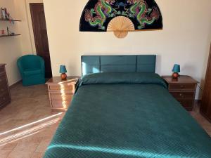 a bedroom with a green bed and two night stands at MAREMONTI alloggio turistico in Formia