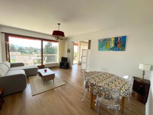 a living room with a couch and a table at Au Beau Voyage à 2 pas des Thermes in Thonon-les-Bains