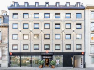a large white building with windows and potted plants at ibis Brussels Centre Chatelain in Brussels