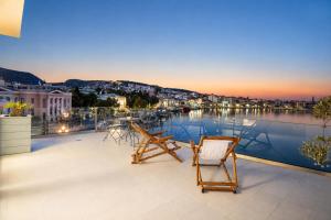 a balcony with chairs and a view of a harbor at Utopia View in Mytilene
