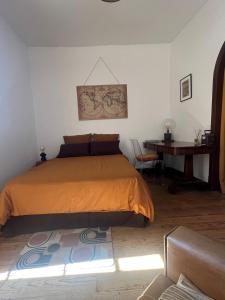a bedroom with a bed and a desk at La Maison de Laulie in Bagnères-de-Bigorre