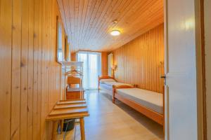 a room with two beds and a staircase in it at self-check-in Hotel Regina Beatenberg in Beatenberg