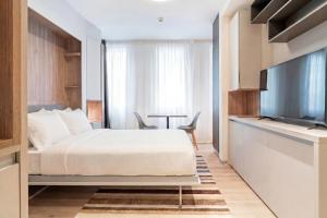 a bedroom with a bed and a flat screen tv at City Pop 2Night Geneva - Self check-in in Geneva +13 photos