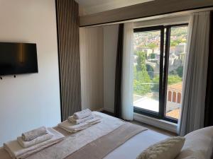 a bedroom with a bed and a large window at Villa Anri in Mostar