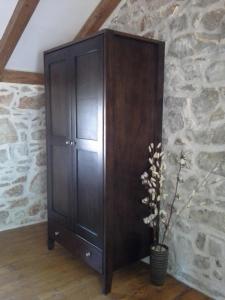 a large wooden cabinet in a room with a plant at Hvar Architect's House in Pitve