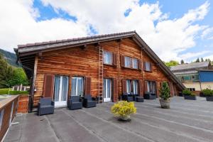 a log house with a large patio at self-check-in Hotel Regina Beatenberg in Beatenberg