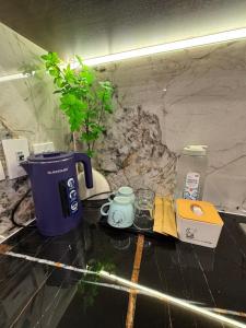 a counter with a coffee maker and a tea kettle at Fuji Apartment in Hanoi