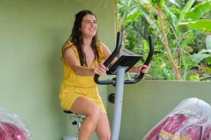 a woman sitting on an exercise bike with a laptop at Cloud Trails Hostel Ella in Ella