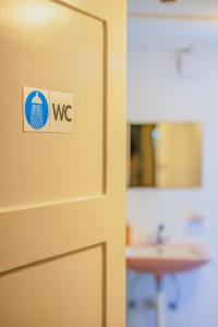 a door with aww sign on it next to a sink at self-check-in Hotel Regina Beatenberg in Beatenberg