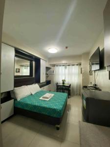 a bedroom with a bed and a desk in it at Horizons 101 in Cebu City +7 photos