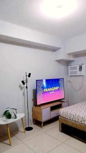 a living room with a flat screen tv and a bed at Horizons 101 in Cebu City
