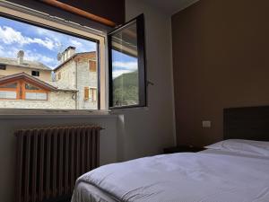 a bedroom with a bed and a large window at La Terrazza di Gino in Grosio