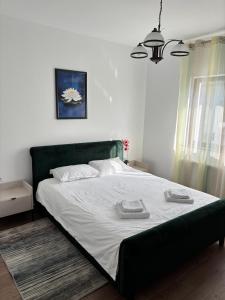 a bedroom with a large bed with two towels on it at Cabana Colț de Rai Ilva Mare in Ilva Mare