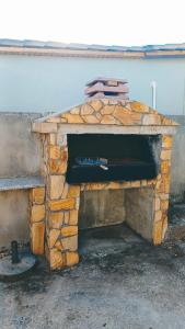an outdoor stone fireplace with a bench next to a building at Grandma's House Aliki Thassos in Alyki