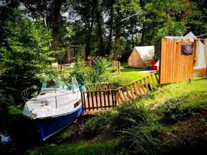a boat parked in a yard next to a wooden fence at La Clef des Ondes in Magescq +13 photos
