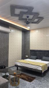 a bedroom with a large bed and a table at Hotel Dhamija Divine inn Sirsa in Sirsa +14 photos