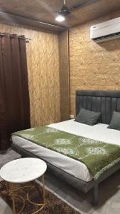 a bedroom with a large bed and a table at Hotel Dhamija Divine inn Sirsa in Sirsa