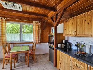 a kitchen with wooden cabinets and a table with a tableablish at Pension am Elberadweg in Radebeul