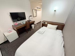 a hotel room with a bed and a desk at Hotel Tetora HonHachinohe in Hachinohe