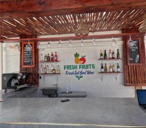a restaurant with a bar with a sign on the wall at Cappuccinovilla in Paje