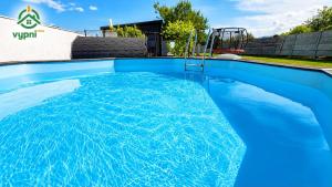a swimming pool with blue water in a house at Chalupa Oslany in Oslany