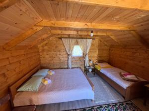 an attic bedroom with a bed in a log cabin at Wooden house in Šavnik