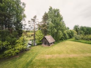 an old cabin in the middle of a grass field at Ezernieki in Valka