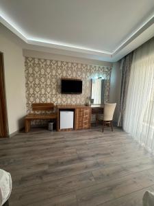 a living room with a fireplace and a flat screen tv at Almero Termal Spa Otel in Termal