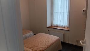 a small room with two beds and a window at Appartement a dinard in Dinard