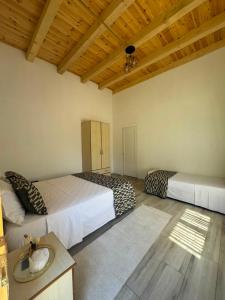 a bedroom with two beds and a ceiling with wood at Guesthouse Bjeshket E Arta in Lëpushë