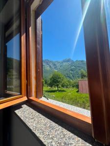 an open window with a view of a mountain view at Guesthouse Bjeshket E Arta in Lëpushë