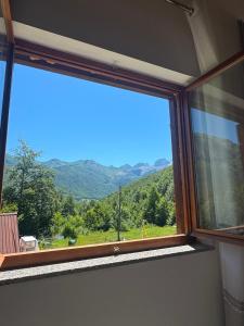 a window with a view of a mountain view at Guesthouse Bjeshket E Arta in Lëpushë +4 photos