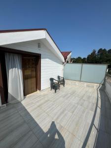 a deck with two chairs and a building at Almero Termal Spa Otel in Termal