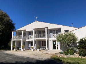 a large white building with a porch and balcony at Les Chênes Verts in Saint-Savinien