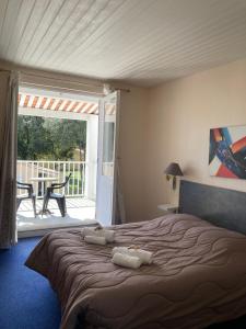 a bedroom with a bed and a balcony with a table at Les Chênes Verts in Saint-Savinien