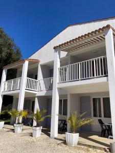 a white building with palm trees in front of it at Les Chênes Verts in Saint-Savinien