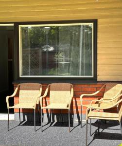 Eine Gruppe von drei Stühlen steht neben einem Fenster in der Unterkunft Asemaseutu in Lapinlahti