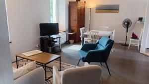a living room with chairs and a table and a tv at Appartement a dinard in Dinard