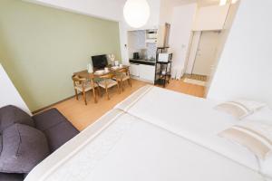 a bedroom with a bed and a living room at 宇都宮ハウスシラユリ in Utsunomiya