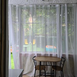 a table and two chairs in front of a window at Happy House Garden in Plovdiv
